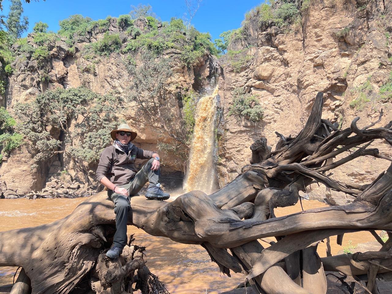 Stefano Marra durante esplorazione sul campo vicino a una cascata in Africa.